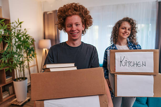 istock Young couple moving boxes into new apartment together 2222900576