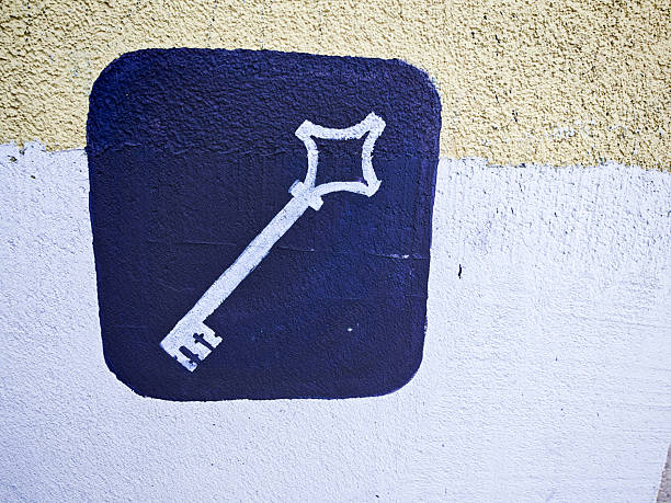 A hand holds a shiny key near a lock on a worn old door