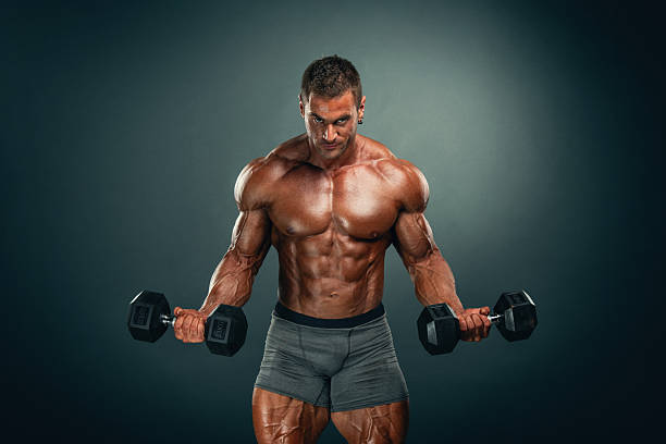 istock Muscular man lifting weights, performing bicep exercise with dumbbells 2222903052
