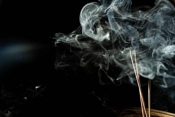istock Blue-white smoke coming from the tip of an incense stick. 2222905310