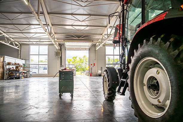 Tractor maintenance service garage with modern tools and industrial equipment inside spacious agricultural workshop.