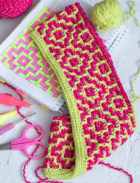 istock Eco friendly modern knitting with bright ethnic pattern. Pink yellow crochet fabric. We knit at home concept. 2222905826