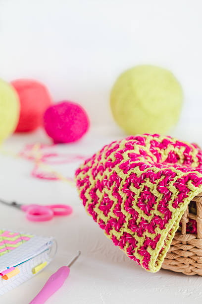 istock The process of creating a tote bag with a bright ethnic geometric pattern. Pink yellow crochted texture. Womans hobby concept. 2222906859