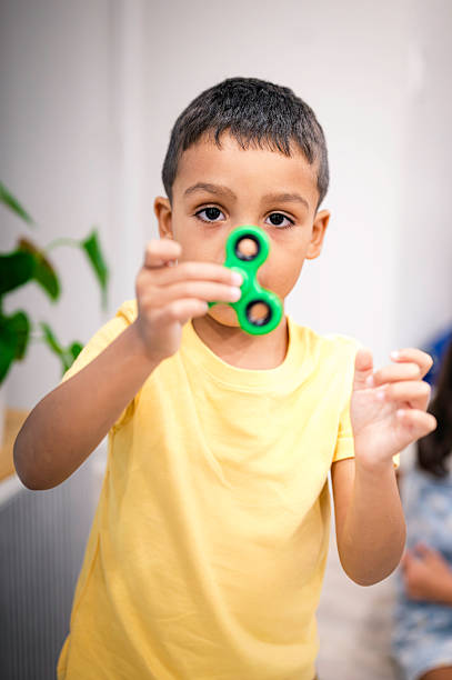 istock Cute little boy plays with a fidget spinner 2222906982