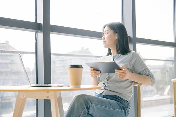 istock Asian woman using tablet computer in coffee shop 2222910803