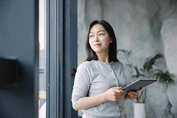 istock Asian woman using tablet computer in coffee shop 2222910869