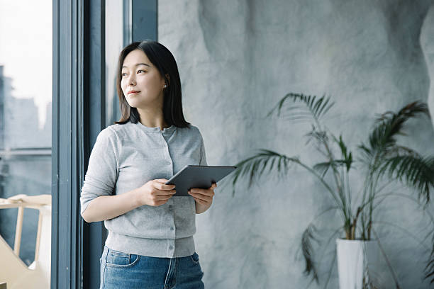 istock Asian woman using tablet computer in coffee shop 2222910889