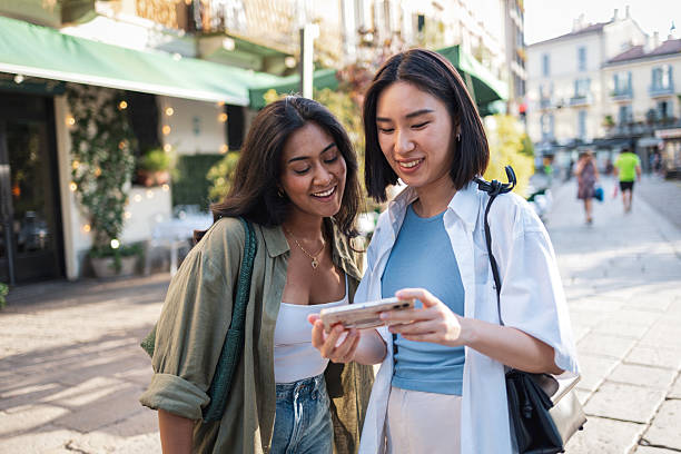 istock Two young women consulting smartphone while walking in milan, italy 2222911268