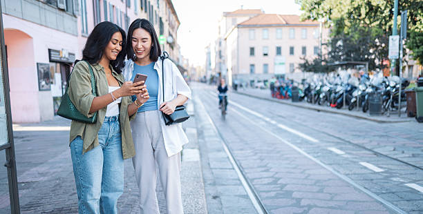 istock Two young women using a smartphone in milan, italy, embracing diversity and inclusion while traveling 2222911272