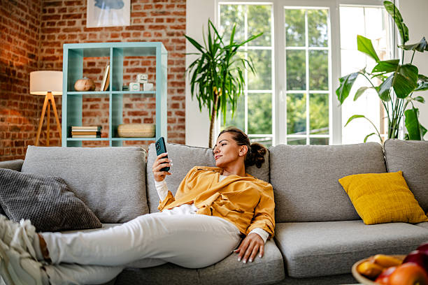 istock Woman enjoying leisure time while relaxing on a couch in a cozy living room setting 2222912367