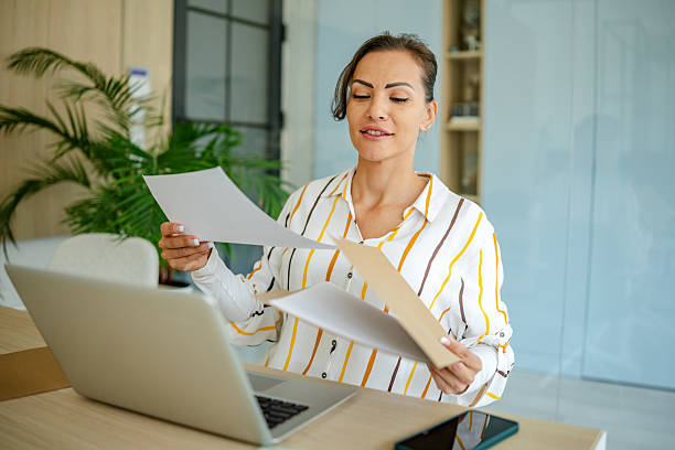 istock Professional woman organizing documents while working at her desk in a modern office space during daytime 2222916420