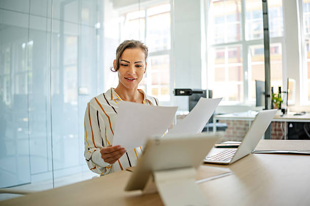 istock Woman reviewing documents in a modern office setting during the day 2222919080