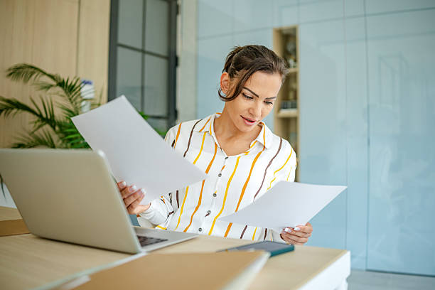 istock Woman reviewing documents while working at a modern desk in a bright office space during daytime 2222919142