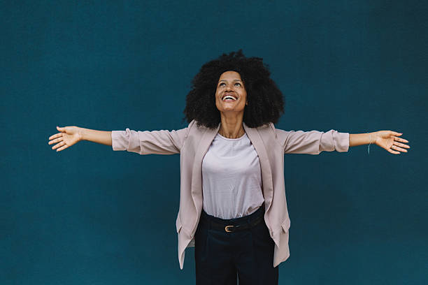 istock Woman with open arms smiling at the sky 2222919455