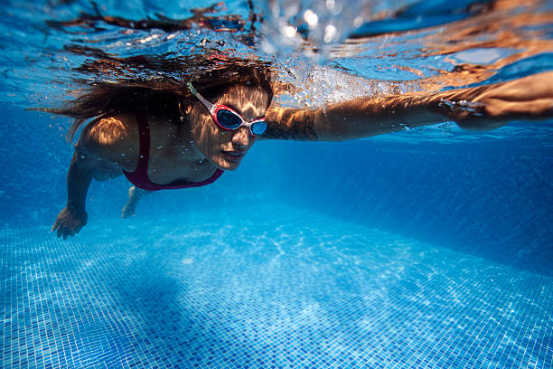 istock Focused Female Swimmer in Bright Blue Pool 2222920028