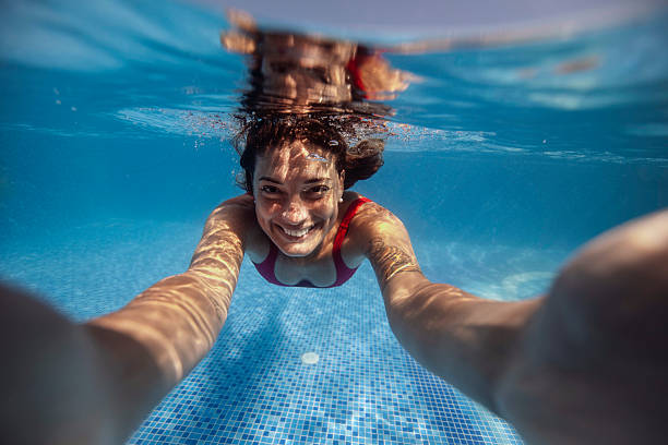 istock Smiling Woman Swimming Underwater in Pool 2222920738