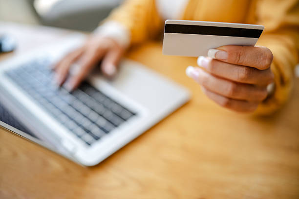 istock Woman using credit card to make online payment while sitting at desk 2222921174