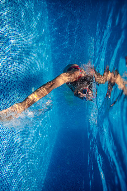 istock Woman Swimming Underwater in a Clear Blue Pool 2222921383