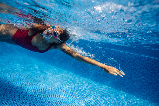 istock Woman Swimming Underwater in Blue Pool 2222923228