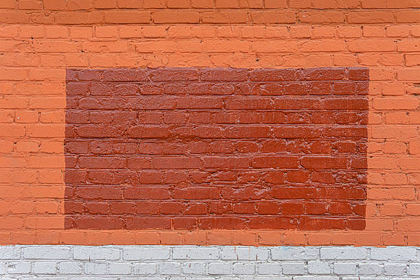 istock A dark red triangle is painted on a red brick wall. 2222923776