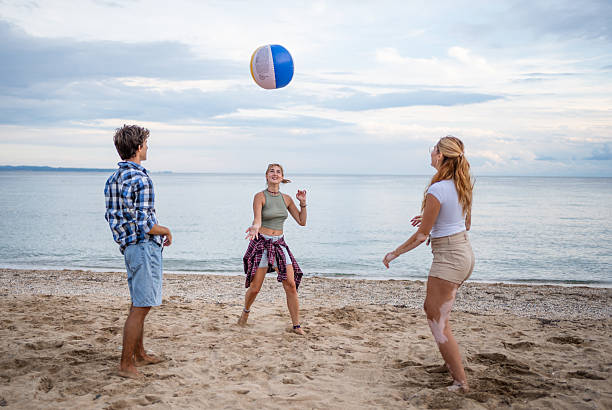 istock Young friends playing beach volleyball on a cloudy day 2222924506