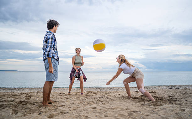 istock Young friends playing beach volleyball on a cloudy day 2222924917