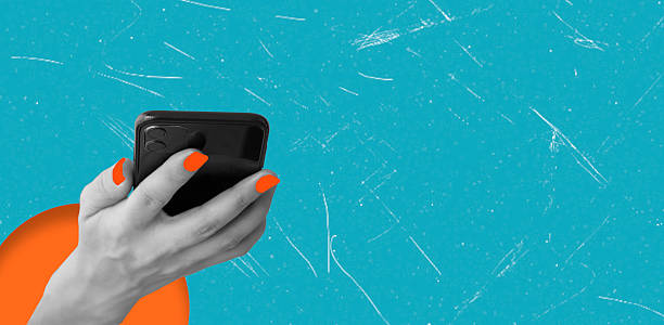 istock Art collage, Bright hand holding a smartphone with bright orange nails on a flesh colored background 2222925253