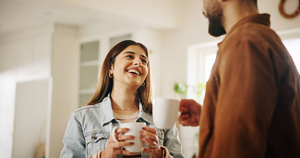 istock Conversation, happy and couple with coffee in kitchen for bonding, connection or drinking together. Smile, love and man with woman for enjoying caffeine beverage in morning with talking in home. 2222926267