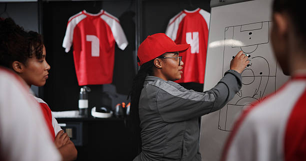 istock Women, coach and writing with whiteboard for soccer game plan, match or player formation in locker room. Female people, coordinator or teaching sports team with presentation or meeting for strategy 2222927657