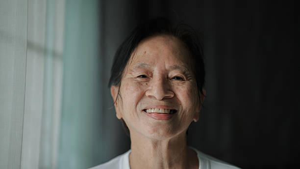istock Mature Asian woman smiling while spending time after retirement at home. 2222928520