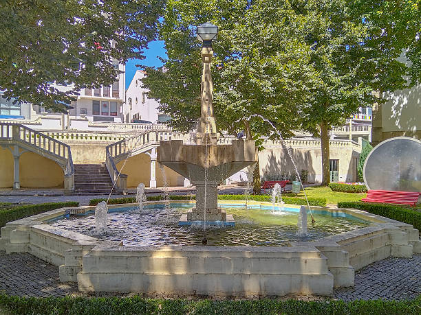 istock Stone fountain surrounded by trimmed hedges 2222929484