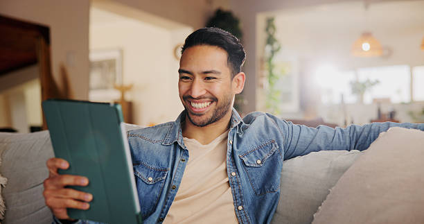 istock Home, sofa and man with tablet for laughing, streaming online and entertainment with comedy show. House, lounge and male person with digital for application, funny video and happy on social media 2222931691