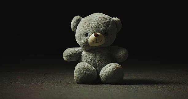 istock Night, shadow and teddy bear in studio for loss, isolation and forgotten toy on ground. Dark, floor and stuffed animal on black background for neglect, abandonment and unwanted with lost hope 2222936267