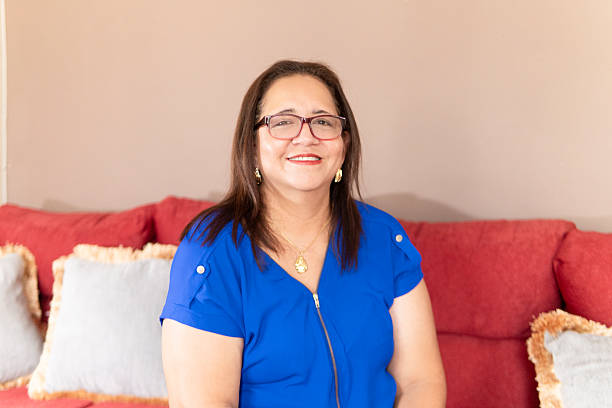 istock Smiling hispanic senior woman sitting on sofa, looking at camera 2222937395