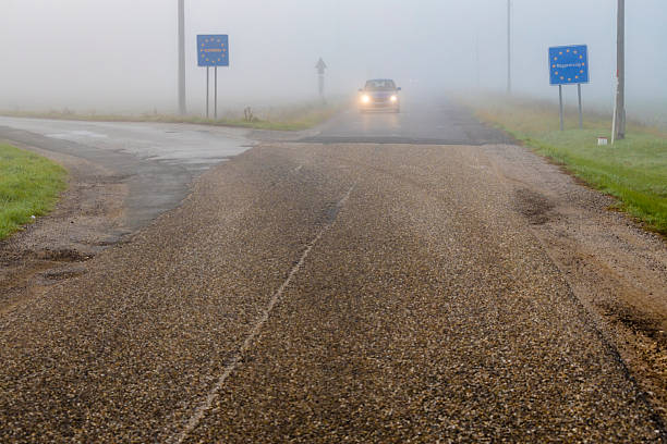 istock Car driving through dense fog at border crossing 2222938025