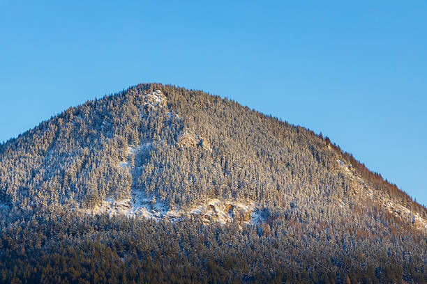 istock Snow covered mountain peak rising into blue sky in winter 2222938087