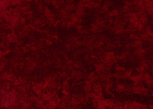 dark red crushed velvet texture close-up, soft luxurious fabric background for design. dark red fluffy carpet for interior floor covering.