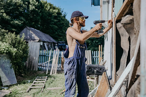 istock male builder restores old wooden house, replacing boards 2222945392