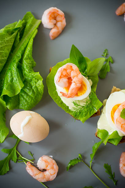 Appetizing breakfast with shrimp, egg and greens from above