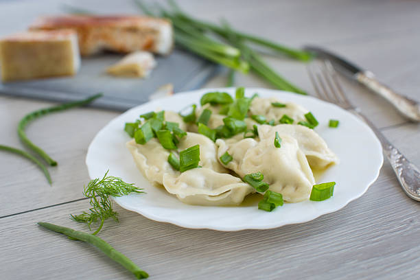 Appetizing dumplings with potatoes and onions on a rustic table.