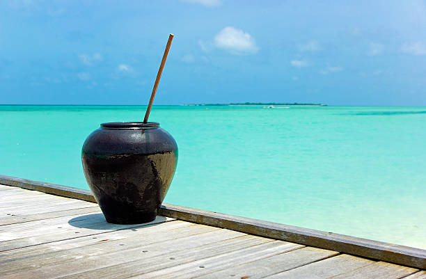 Shiny black bowl or vase on wooden brigde overblue ocean