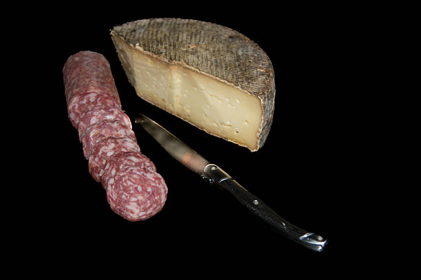 Piece of cheese. Tomme de Savoie accompanied by a delicious sausage.