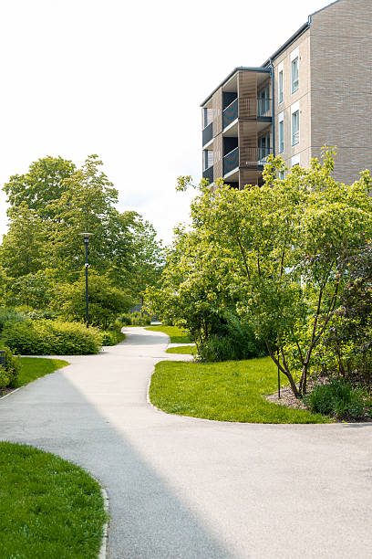 istock Curved Pathway in Park with Trees and Modern Building Nearby 2222958609