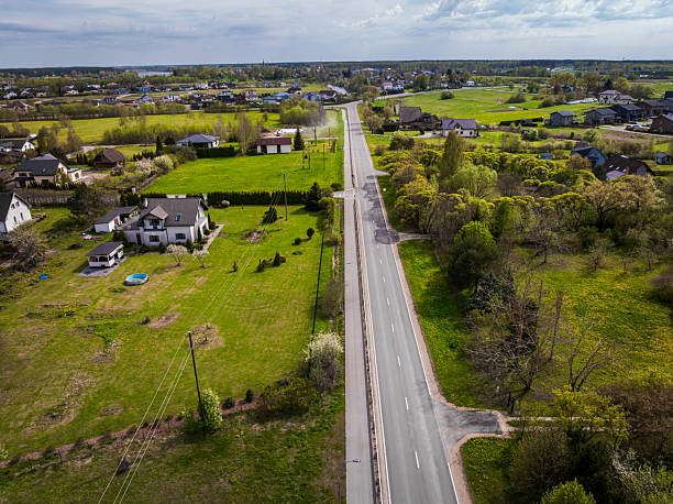 istock Straight Paved Road Through Rural Area with Houses and Fields 2222959385