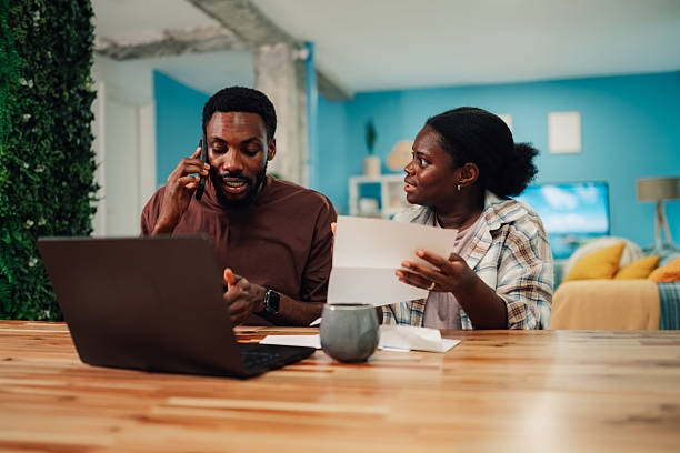 istock Couple arguing about bills while calling on phone at home 2222959884