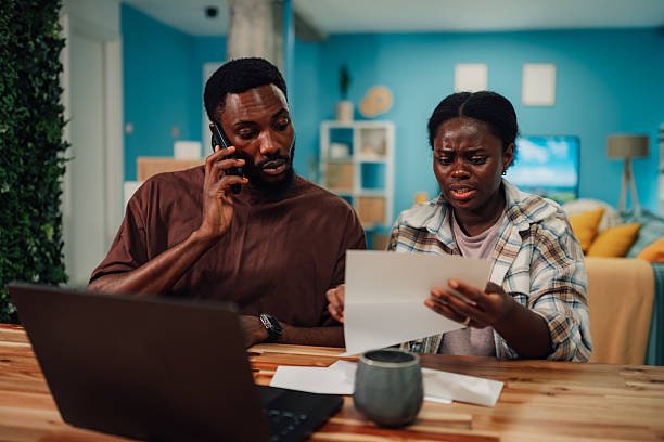 istock Worried couple reading mail and calling customer service at home 2222959888