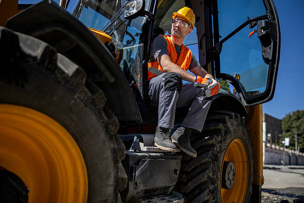 istock Construction worker sitting on a bulldozer after a long day of work under the clear blue sky in an urban area 2222961637