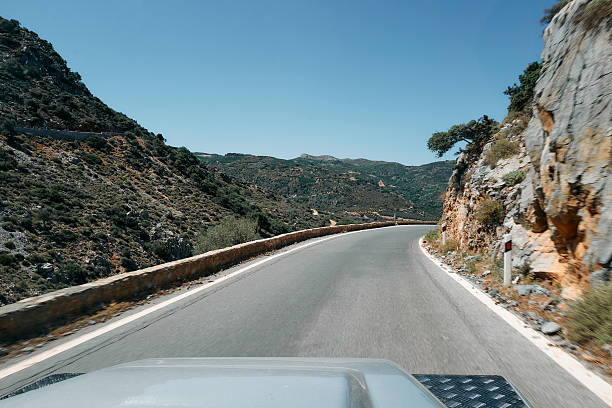 istock A car is driving down a road with a beautiful mountain range in the background 2222961995