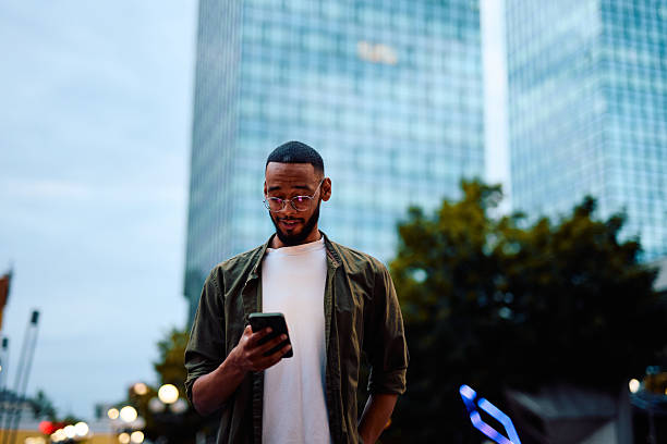 istock Young businessman using smartphone in front of modern buildings 2222963827