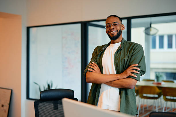 istock Confident young manager smiling with arms crossed in modern office 2222963840